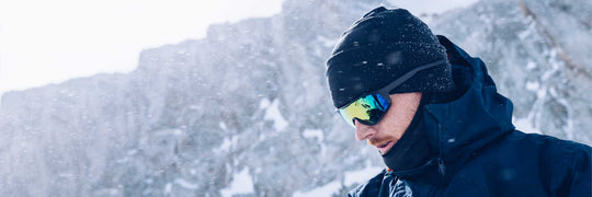 Man wearing skiing sunglasses in snowy mountains