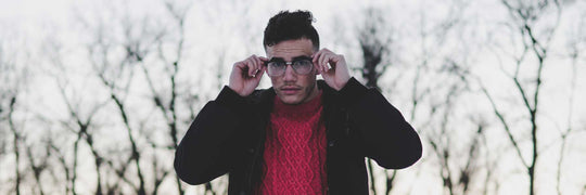 Young man outside on cold day wearing jacket and eyeglasses frame