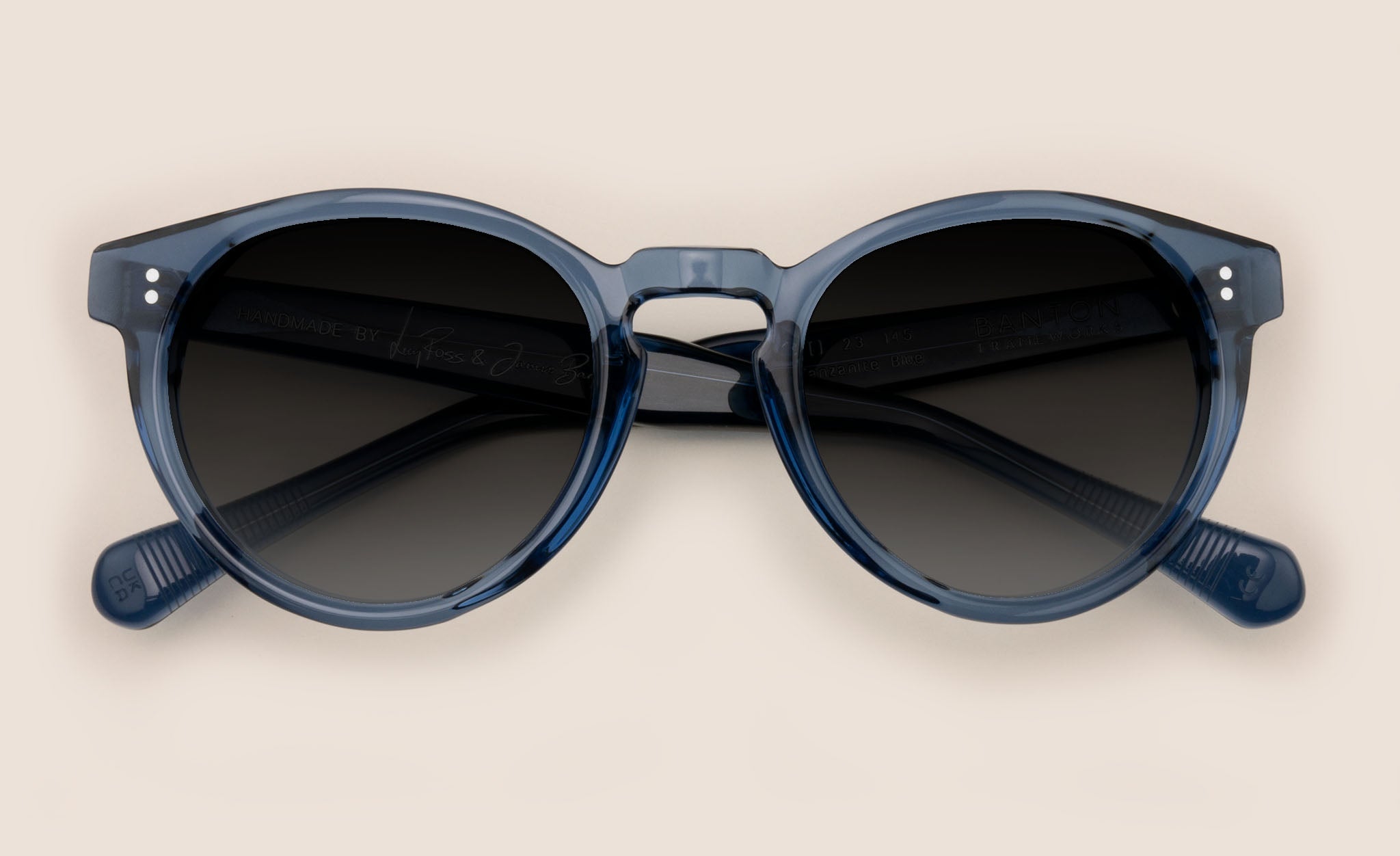 Front view of oval blue sunglasses frame with dark grey lenses